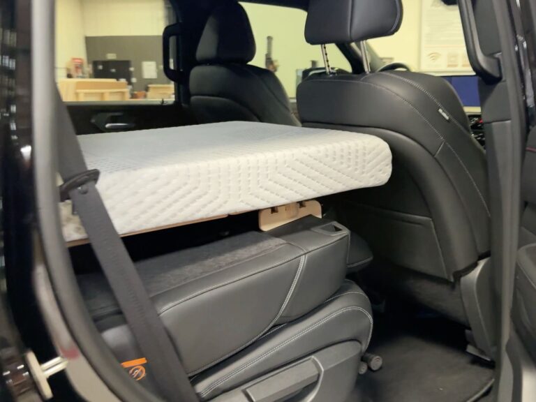 A Trunk Mate Sleeping Platform mattress set up across the folded back seats of a car, creating a comfortable sleeping spot for your next road trip adventure.