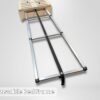 Adjustable bed frame featuring sturdy metal rails, a supportive central strap, and a slatted wooden head section; perfect for transforming your trunk into a comfy sleep setup. Plain background keeps the focus on the innovative design. Text at bottom: “Adjustable Bed Frame.”.