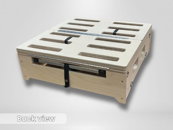 Trunk Mate wooden slotted folding platform viewed from the back, showing easy-carry cut-out handles, sturdy metal hinges, and black straps holding it together—practical design for van and SUV camping.