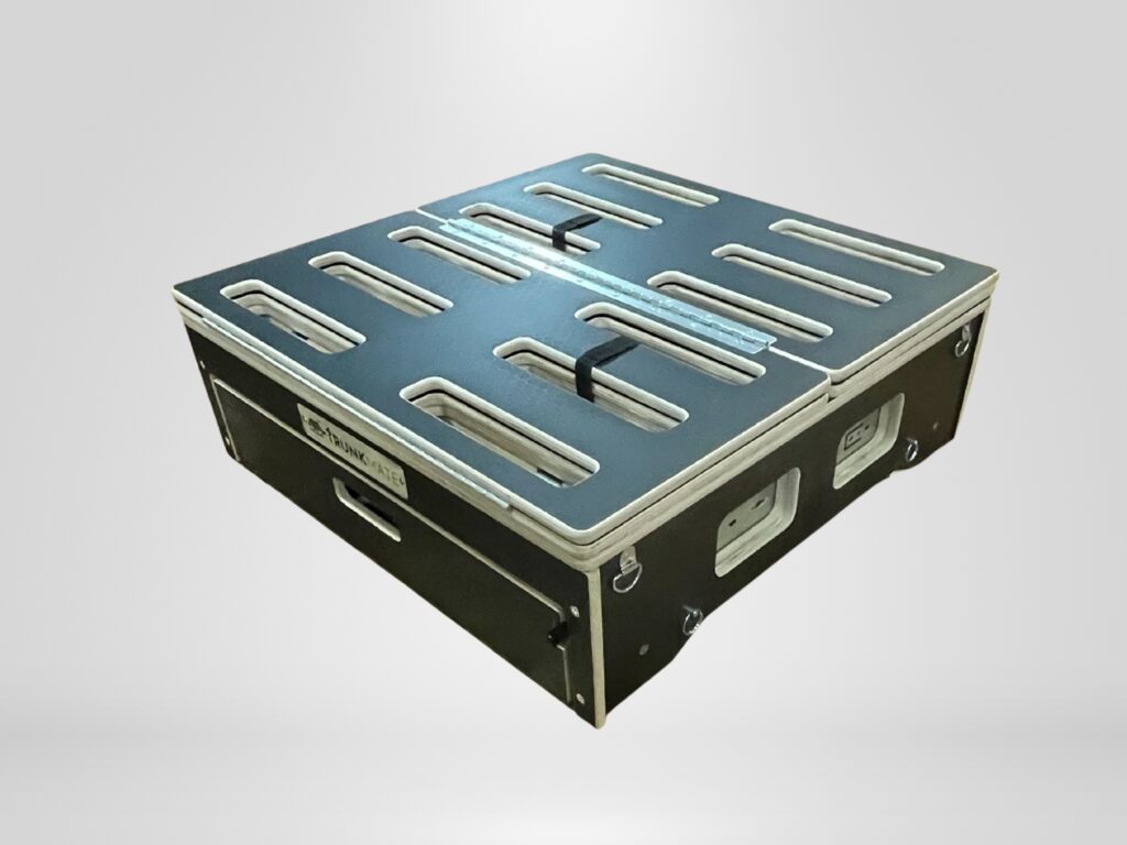 Rectangular black storage crate with metal edges, top vents, side handles, and a "SKYMARK AIR" label—tough Trunk Mate gear.