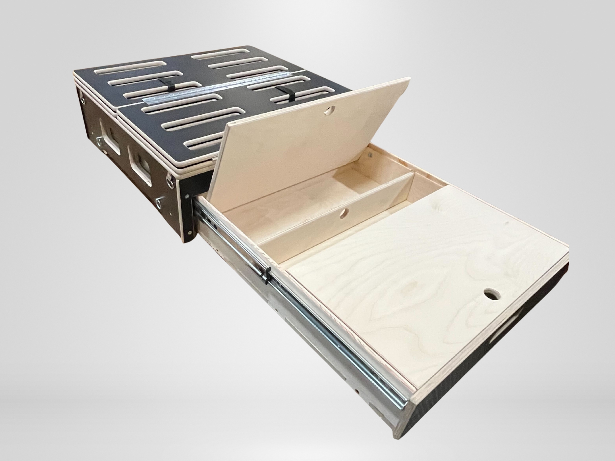 Trunk Mate platform: wooden drawer system shown partially open, with inner storage sections and a hinged lid, on a plain backdrop.