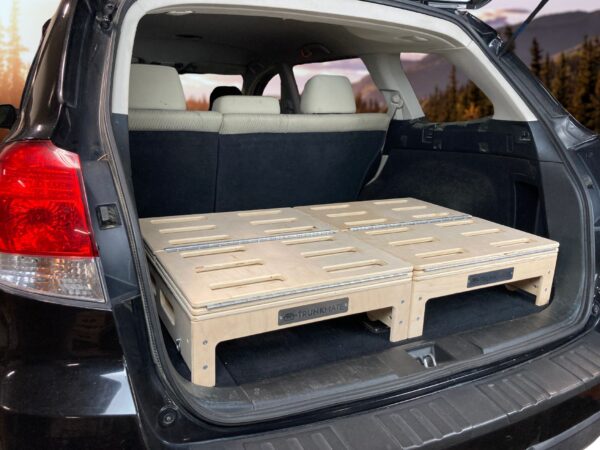 SUV rear with hatch open, featuring a TrunkMate wooden storage sleeping platform neatly installed in the cargo area, ready for adventure.