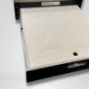 A Trunk Mate sliding wooden drawer with a handy pull handle and circular cutout, partially pulled out from a sleek black frame featuring the Trunk Mate logo—perfect for organized, on-the-go storage in your adventure rig.