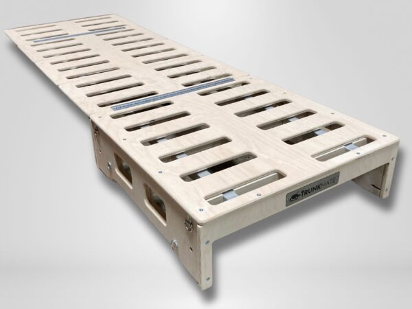 Trunk Mate foldable wooden bed platform with sturdy slats, shown partially unfolded—simple, portable sleep setup made easy.