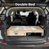 Trunk Mate’s double bed platform with drawer fits in an SUV trunk, featuring adjustable height and length for custom comfort.
