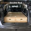 Trunk Mate double bed with two storage drawers in an SUV, featuring adjustable height and length dimensions for a custom fit.