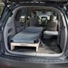 Trunk Mate Sleeping Platform with a mattress fits in a minivan, maximizing space by replacing rear seats for comfy sleep.