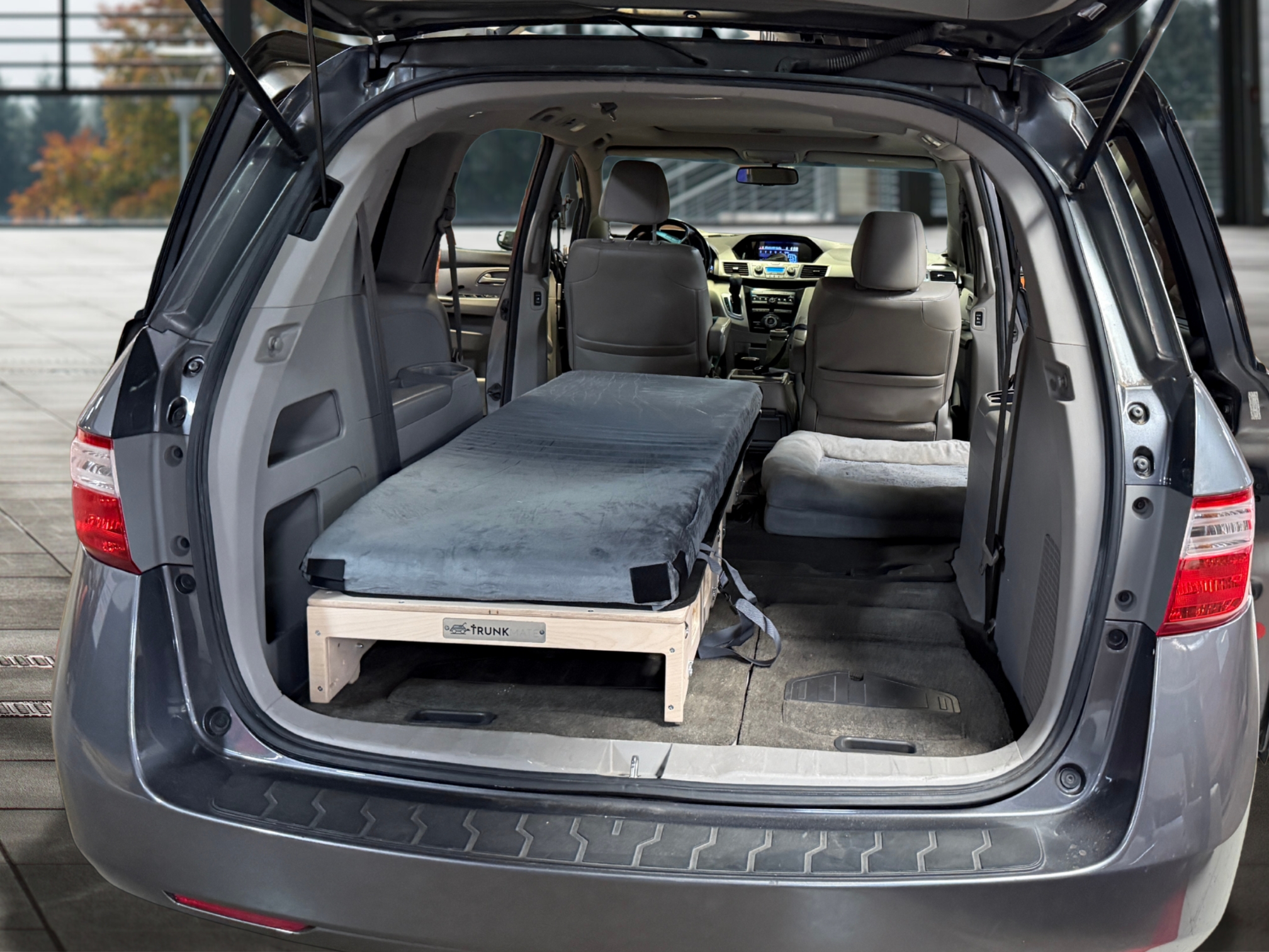Trunk Mate Sleeping Platform with a mattress fits in a minivan, maximizing space by replacing rear seats for comfy sleep.