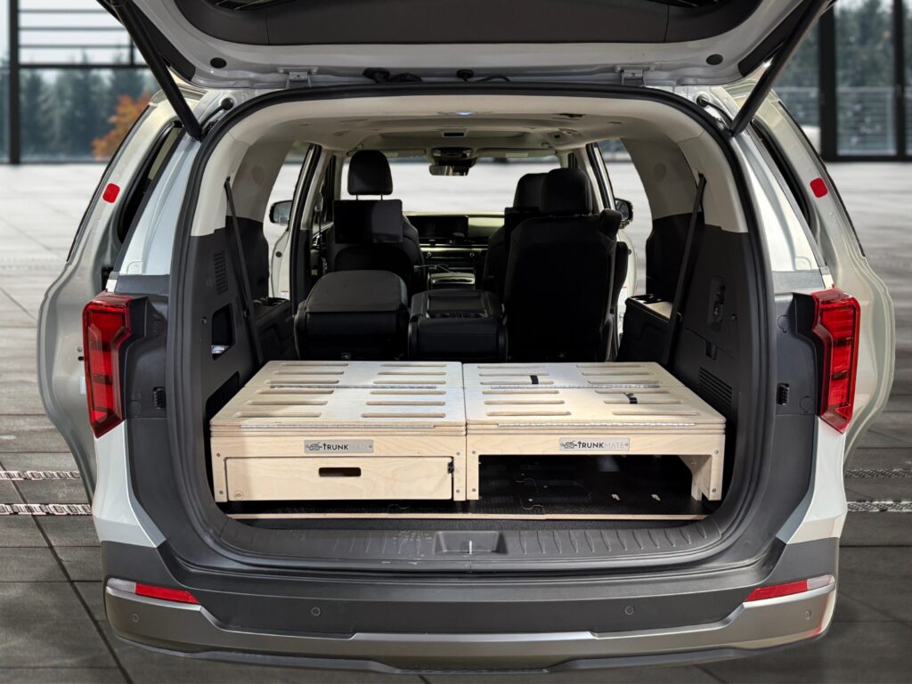 An SUV trunk with a Trunk Mate wooden storage platform and organized compartments set right behind the rear seats.